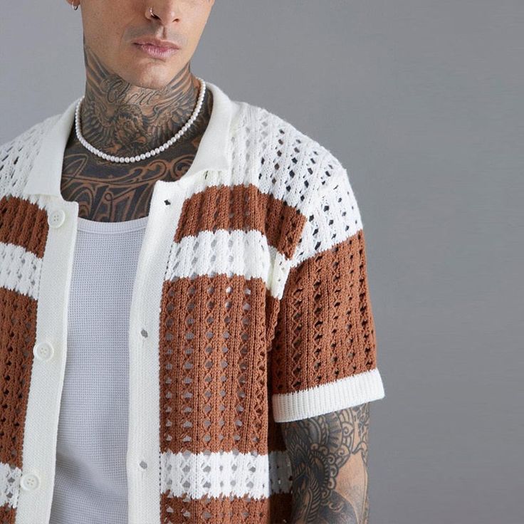 tattooed man wearing knitted shirt short sleeves.