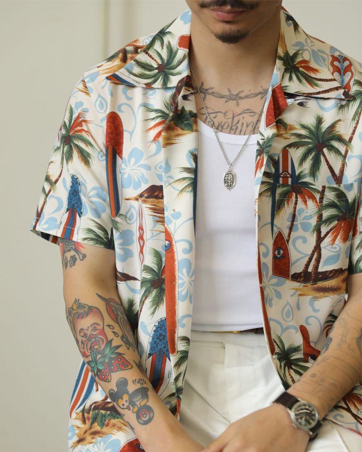 man with tattoo, wearing tropical palm tree shirt, white tank top underneath
