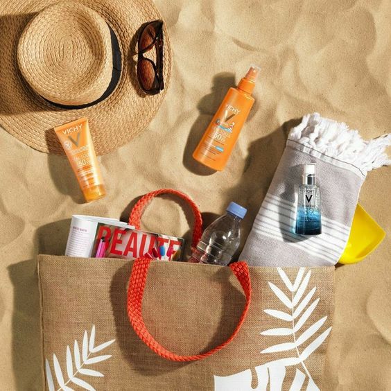 a tote bag with beach items like sunscreen, hat,...